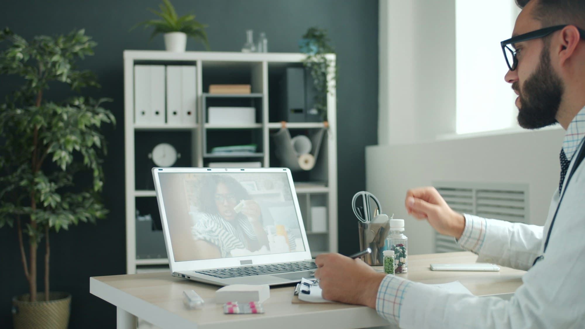 A healthcare provider reviewing symptoms with a patient over a virtual video visit